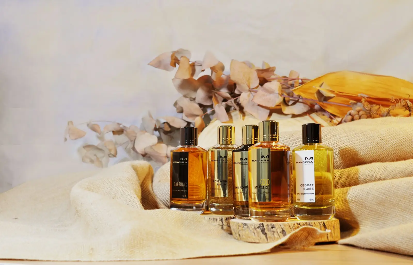 Flacons de parfum ambrés sur tissu crème